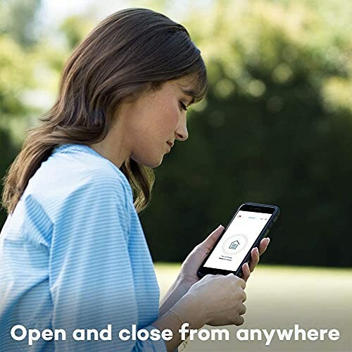 Woman using smartphone outdoors to control a device